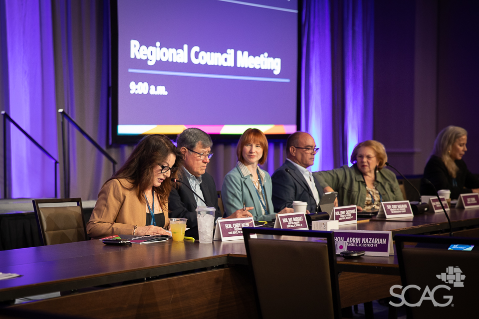 Panel discussion at a Regional Council Meeting, people seated at a conference table.