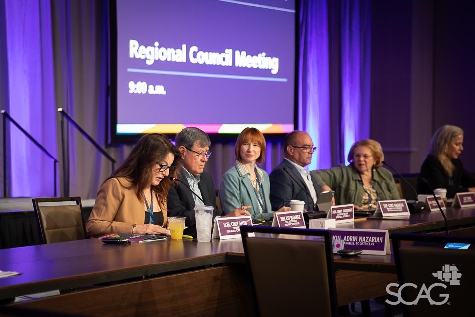 Panel discussion at a Regional Council Meeting, people seated at a conference table.