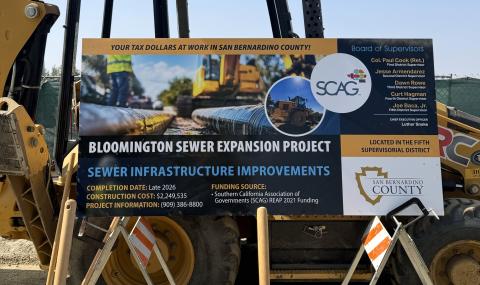 Construction sign for Bloomington Sewer Expansion Project with logos and text.